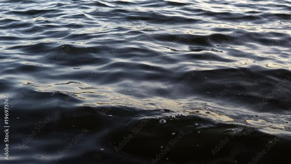 UHD Close up of dark water rippling gracefully with the camera near the surface of the water UHD Close up of dark water rippling gracefully with the camera near the surface of the water