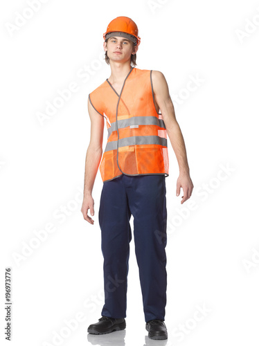 A young worker in a summer orange mesh vest in a helmet.