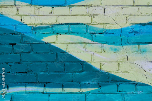 Colorful (yellow and turquoise) painted brick wall as background, texture