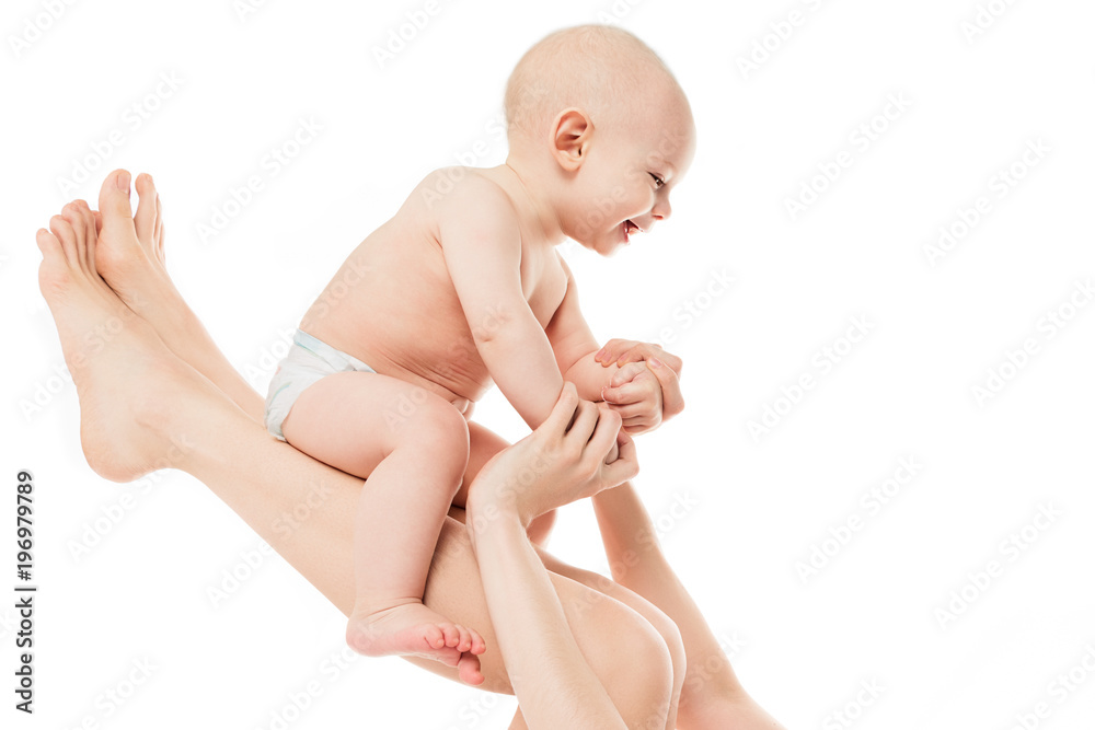 Happy mother lifting her adorable baby son in the air. Happy family. Laughing baby portrait isolated on white background. Happy mother lifting her adorable baby son in the air. Happy family. Laughing baby portrait isolated on white background.