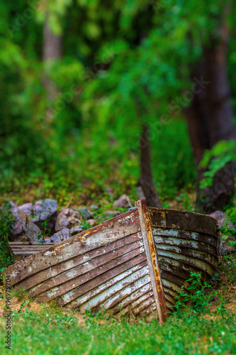 Fototapeta Naklejka Na Ścianę i Meble -  Photo of old rusty boat in the forest near the river