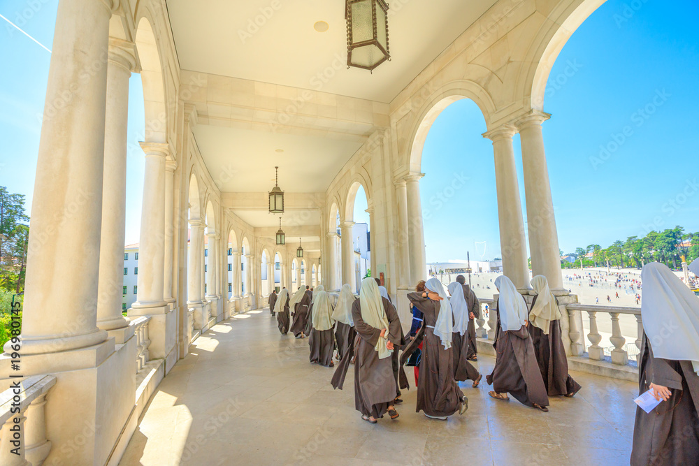 Φωτογραφία Fatima, Portugal - August 15, 2017: group of nuns walks under arcade at Sanctuary of Our Lady of Fatima, one of the most important Marian Shrines and pilgrimage locations for Catholics