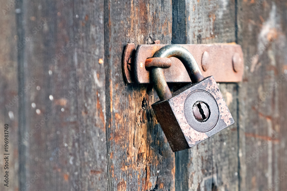 Old rusty padlock on wooden gate Old rusty padlock on wooden gate