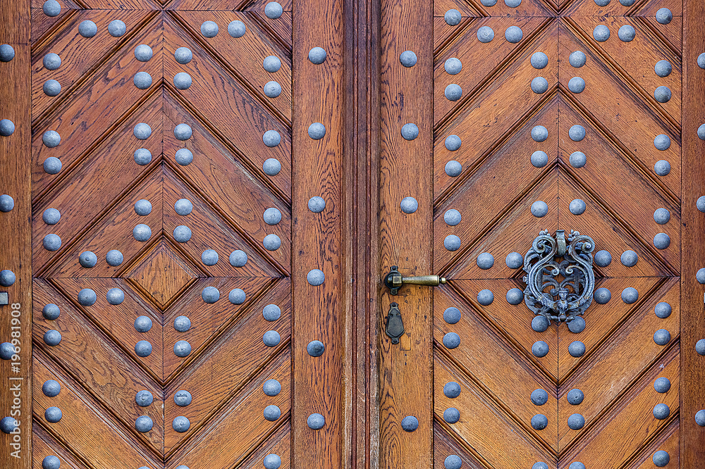 Fototapeta premium Wooden door with handle ring and iron rivets