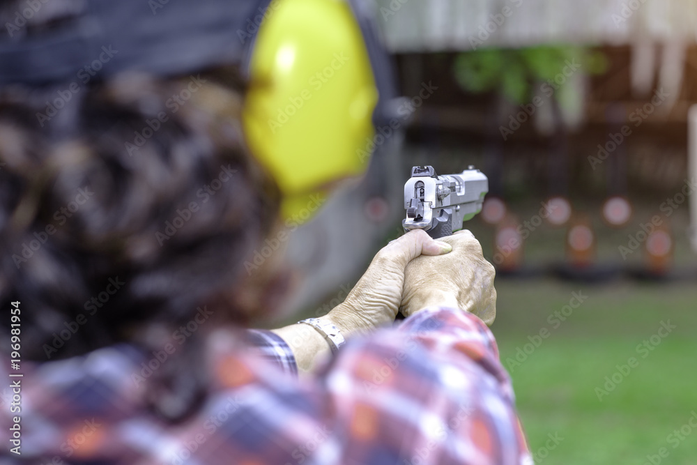 Short magazine gun in hand of old woman being for practice on arm and weapon martial art for woman Short magazine gun in hand of old woman being for practice on arm and weapon martial art for woman