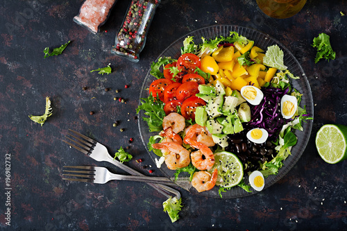 Healthy salad plate. Fresh seafood recipe. Grilled shrimps and fresh vegetable salad - avocado, tomato, black beans, red cabbage and paprika. Grilled prawns. Healthy food. Flat lay. Top view