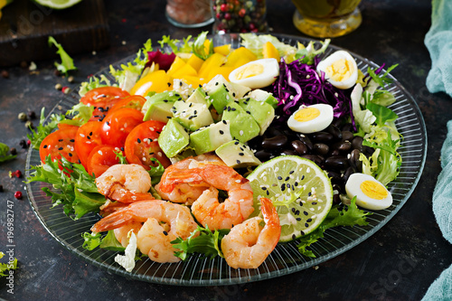 Healthy salad plate. Fresh seafood recipe. Grilled shrimps and fresh vegetable salad - avocado, tomato, black beans, red cabbage and paprika. Grilled prawns. Healthy food.