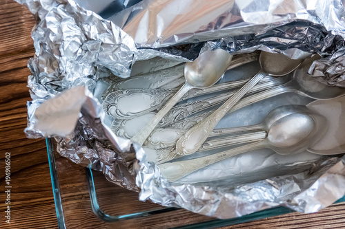 Foto Cleaning dishes. Melchior spoons and forks in foil