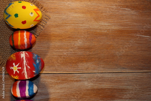 красивые разноцветные пасхальные яйца лежат на деревянных досках 