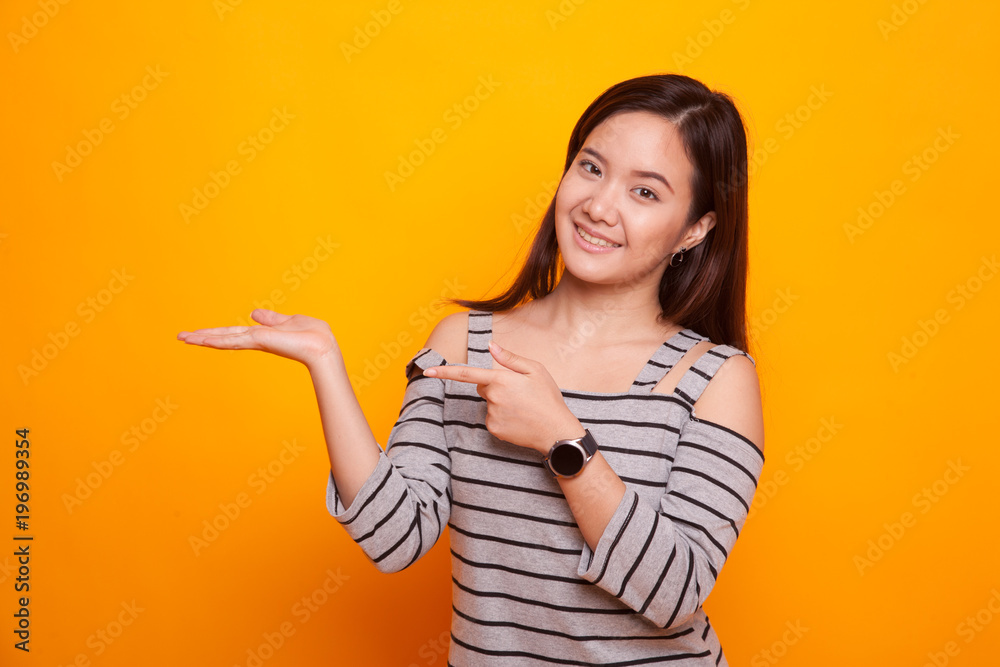 Beautiful young Asian woman point to palm hand.