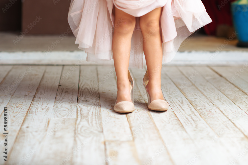 A little girl wearing mums shoes A little girl wearing mums shoes