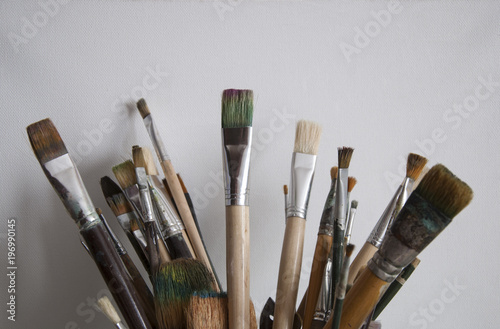 Many art brushes for oil and acrylic paints on the background of canvas
