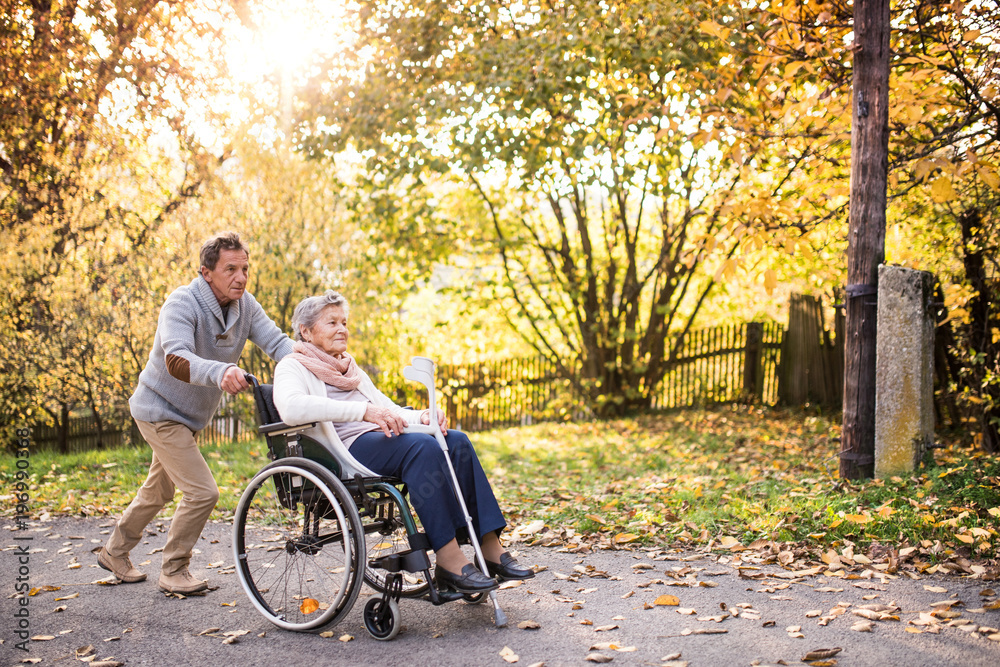 Senior man and woman in wheelchair in autumn nature. Senior man and woman in wheelchair in autumn nature.