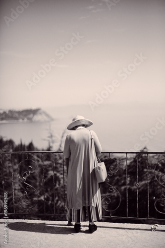 A woman's back on a terrace overlooking sea bay in Crimea, Russia 