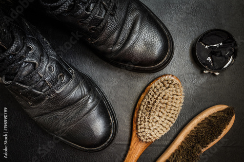 Men's military boots rme shoes, brush and shoe polish against a dark background flat lay top view © shintartanya
