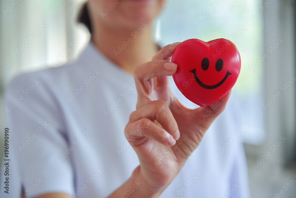 Female nurse holding red heart on hand,good health.