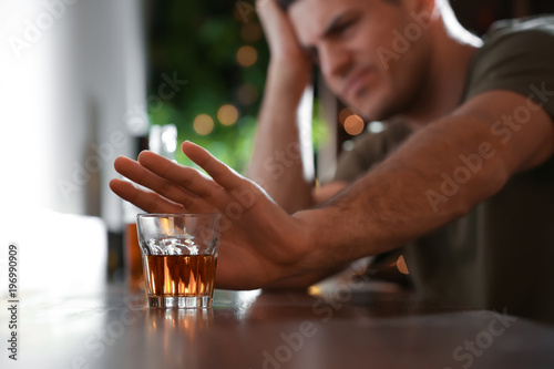 Man refusing to drink alcohol in bar, closeup