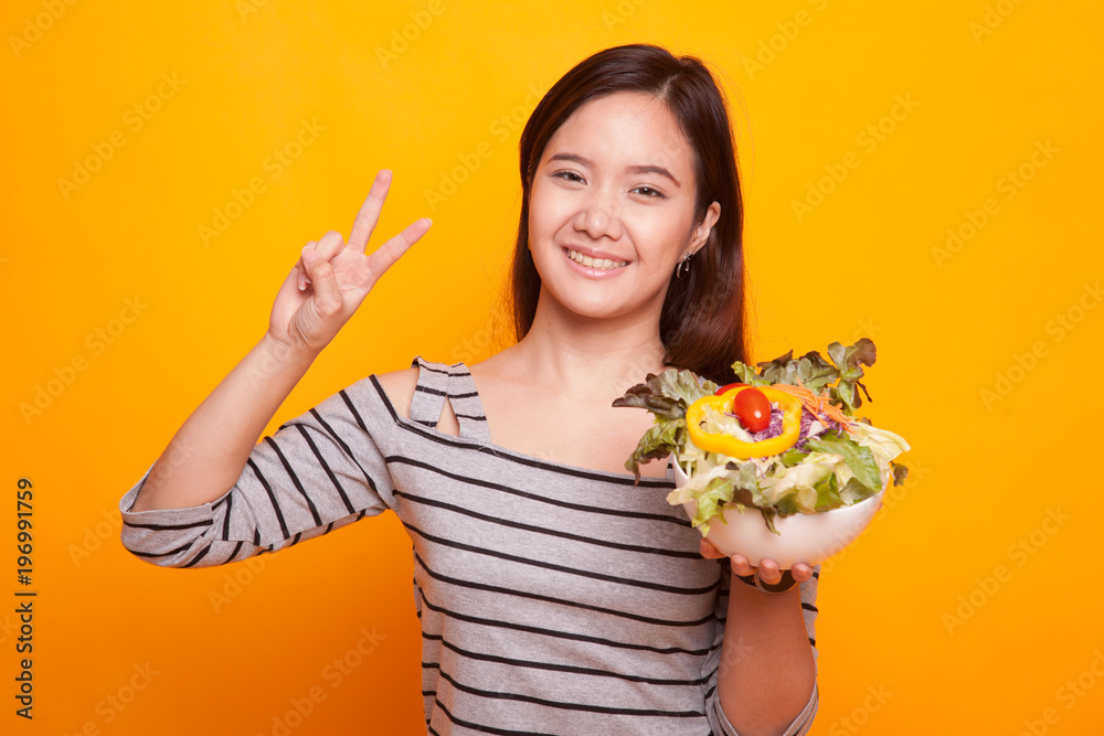 Healthy Asian woman show victory sign with salad. Healthy Asian woman show victory sign with salad.