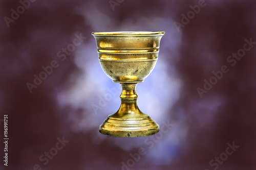 Old chalice on red clouds background