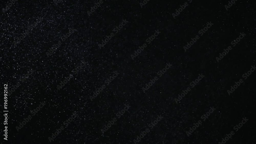 Natural organic dust particles on black background. Glittering Particles With Bokeh. Slow motion.