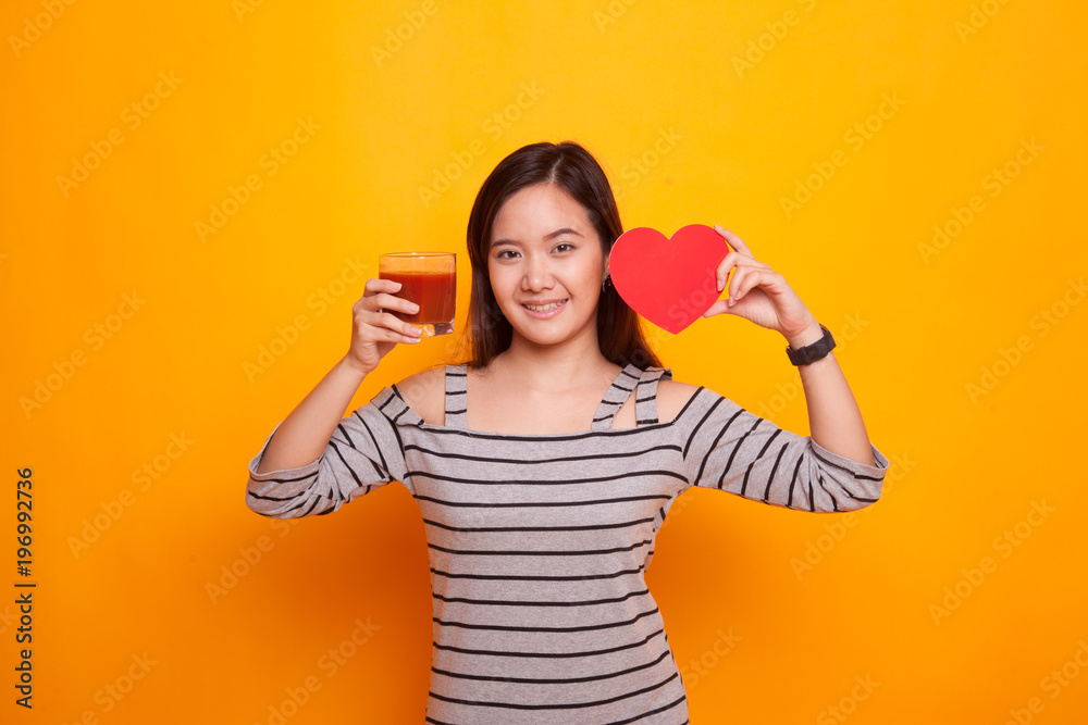 Young Asian woman with tomato juice and red heart. Young Asian woman with tomato juice and red heart.