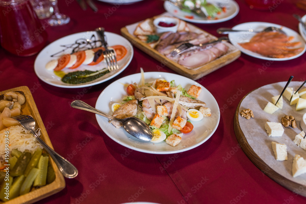 Caesar salad with croutons, quail eggs, cherry tomatoes and grilled chicken in plate on a table. Plate with chicken salad on table