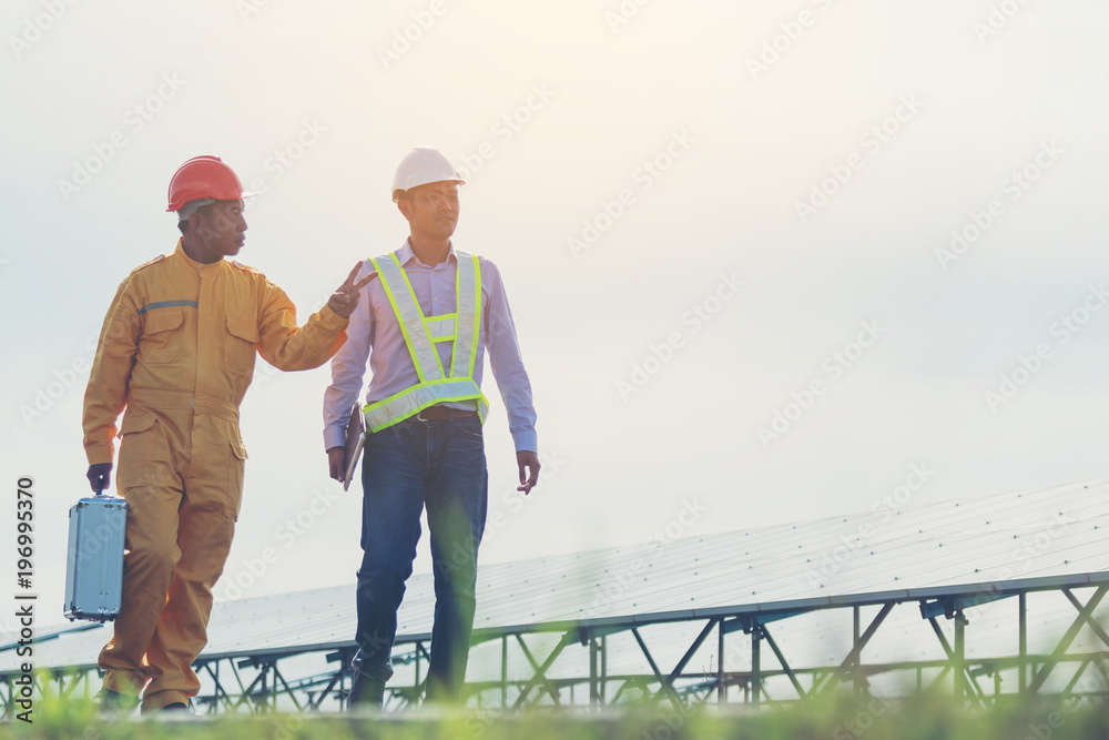 engineer and technician checking efficiency of solar panel at solar power plant ; expertise service team working on measuring efficiency of operation and maintenance at solar plant