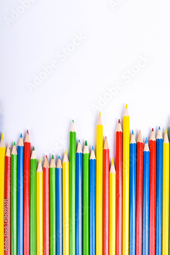 Red pencil standing out from crowd of plenty identical black fellows on white table. Leadership, uniqueness, independence,  initiative, strategy, dissent, think different, business success concept