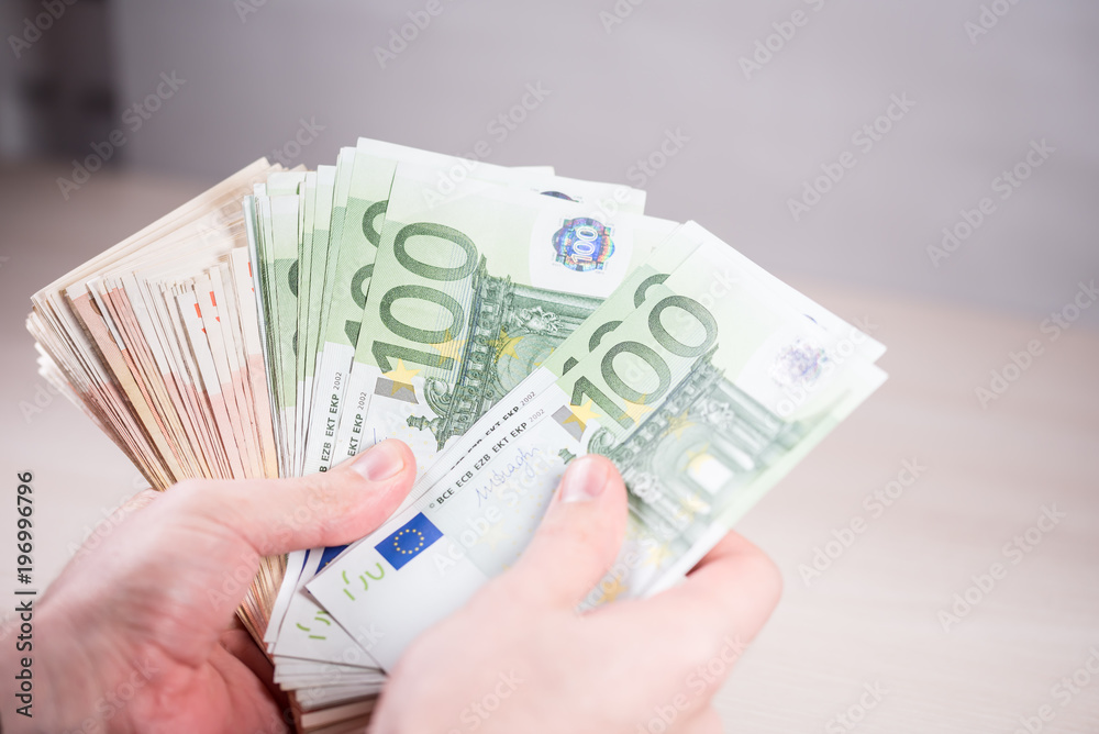 Man holding paper money - euros in the hand Man holding paper money - euros in the hand