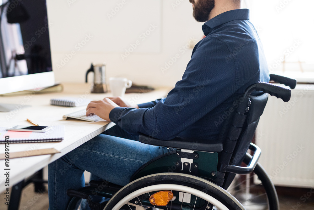 Obraz premium Businessman in wheelchair working in his office.