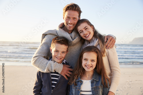 Portrait Of Family Walking Along Winter Beach Together