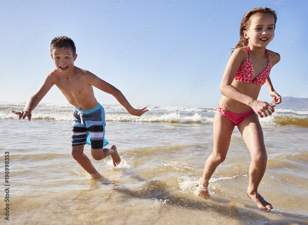 Boy And Girl On Summer Vacation Running Through Waves Boy And Girl On Summer Vacation Running Through Waves