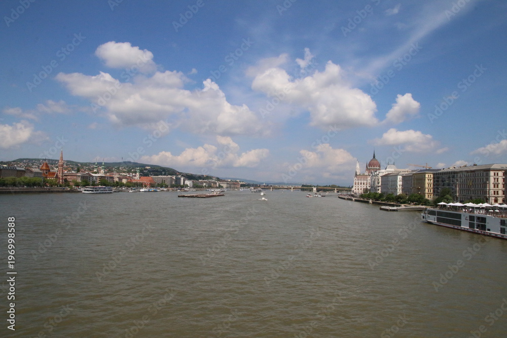 view on the danube river from a Budapest bridge, sunny day and clouds on blue sky