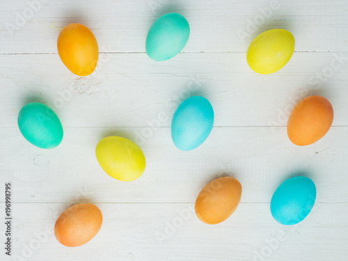 colored Easter eggs on a white table, top view