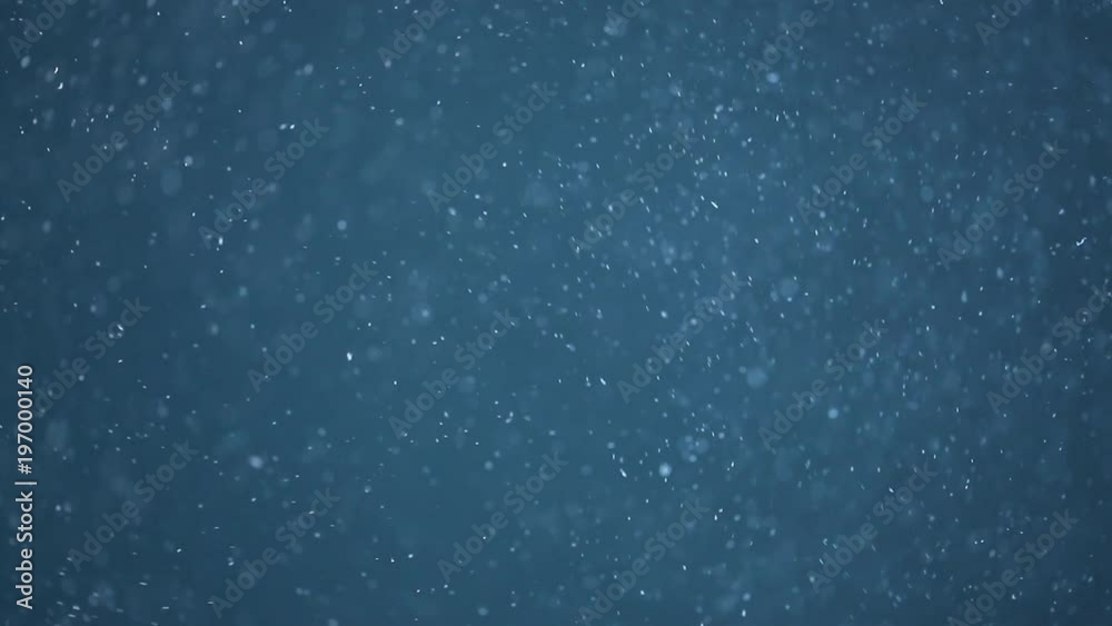 Slow motion of realistic particles on blue background Slow motion of realistic particles on blue background