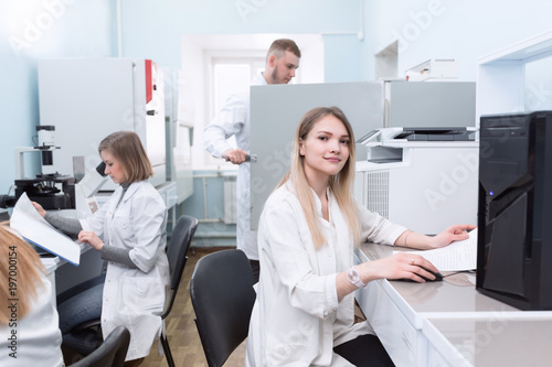 Group of students in laboratory  chemistry class with microscope  computers and laptop