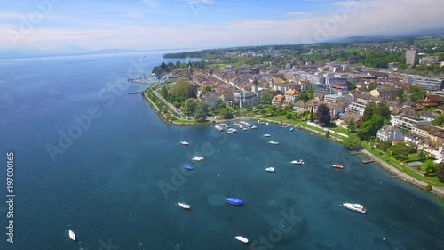UHD Orbit drone shot around the lovely city of Morges - Switzerland. Vivid blue lake on a bright sunny day photo