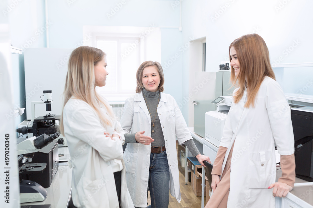 Fototapeta premium Microbiology or Chemistry Faculty students using a microscope and laptop while doing laboratory work