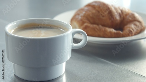 Fototapeta Naklejka Na Ścianę i Meble -  man put cup of coffee on the table closeup video morning light