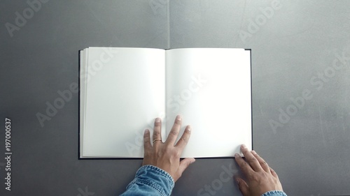 man turning pages of book, magazine with empty white pages