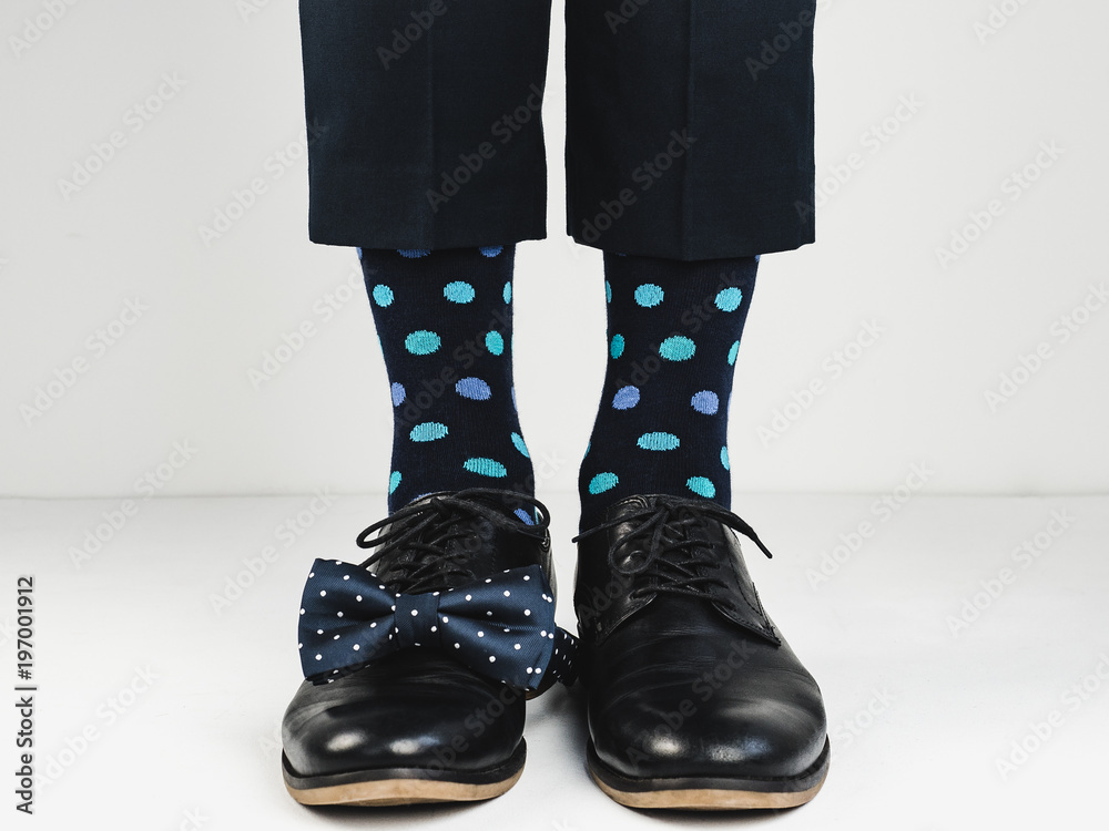 Stylish black shoes, bright socks and a beautiful bow tie on a white background. Style, fashion, beauty