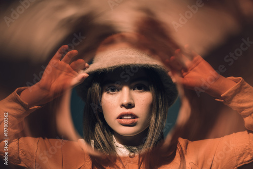 portrait of stylish young woman in hat looking at camera