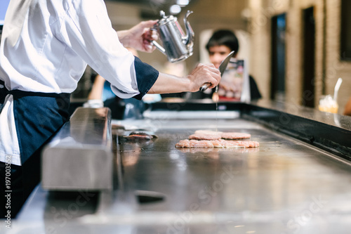 Hand of man take cooking of meat with vegetable grill, Chef cooking wagyu beef in Japanese teppanyaki restaurant