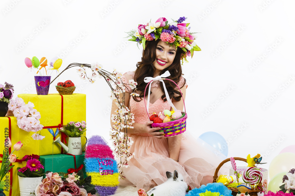 Fototapeta premium Smiling woman holding Easter basket with colored eggs