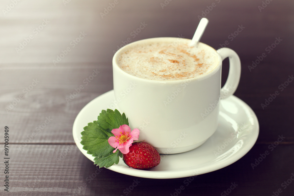 strawberry coffee pause with mood/ red ripe berry with flower and leaf next to a cup of foamy cappuccino sprinkled with cinnamon strawberry coffee pause with mood/ red ripe berry with flower and leaf next to a cup of foamy cappuccino sprinkled with cinnamon