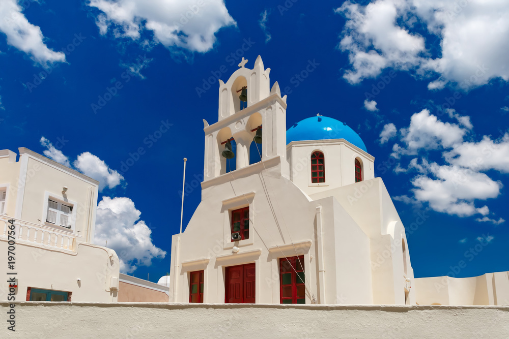 Picturesque view of white church with blue dome in Oia or Ia, island Santorini, Greece