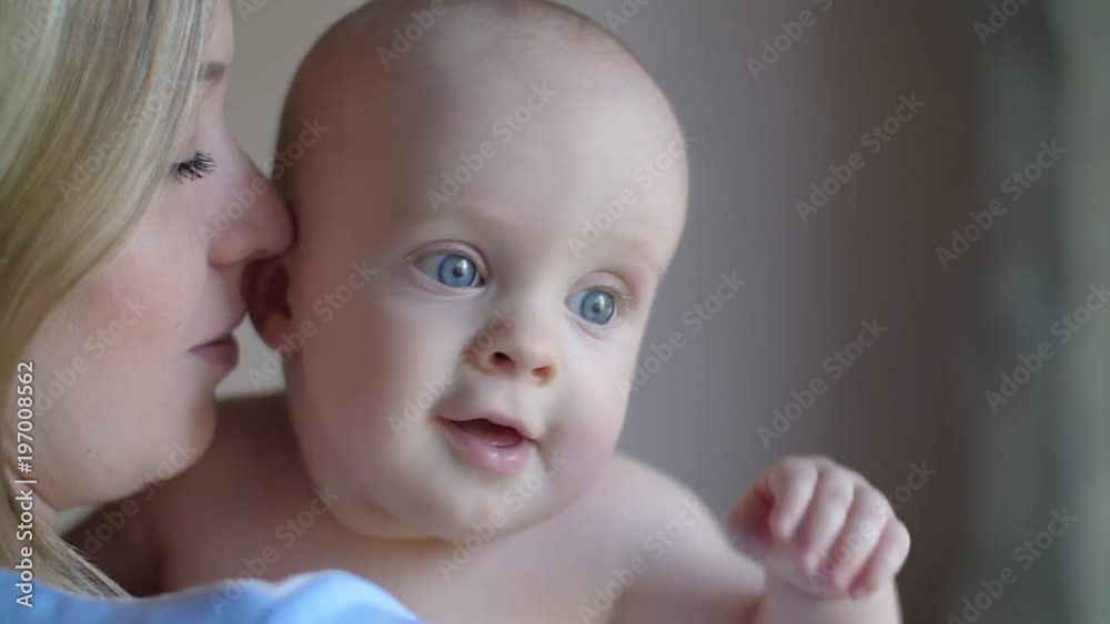 Mom and baby gently played near the window and smile at each other. Affectionate and gentle touches, games. Slow motion Mom and baby gently played near the window and smile at each other. Affectionate and gentle touches, games. Slow motion