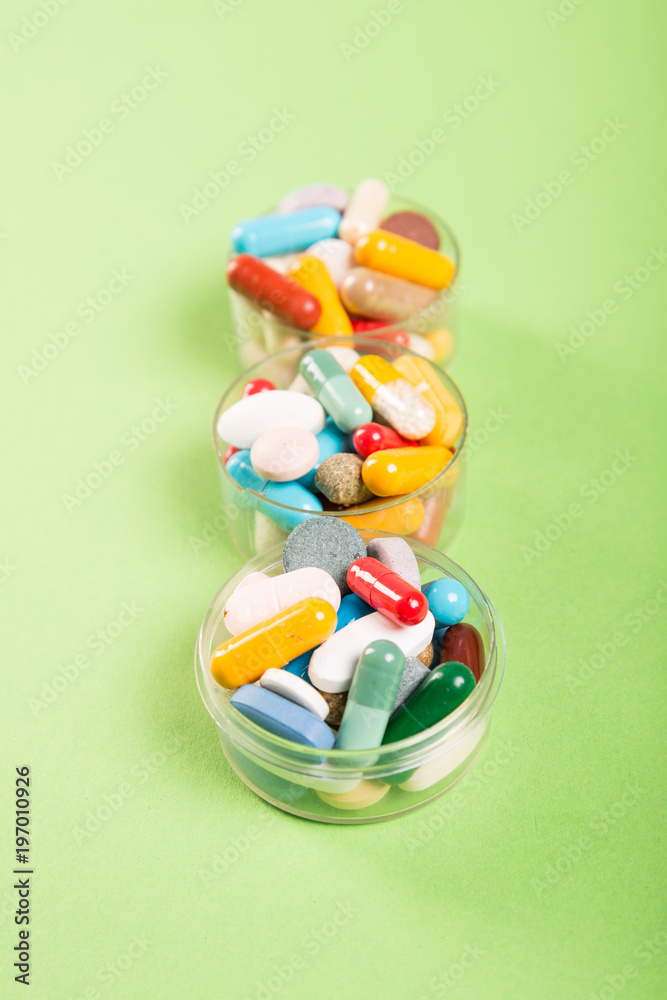 Three cups of colorful pills and tablets. Three cups of colorful pills and tablets.