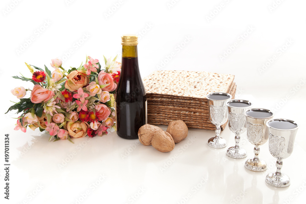 Naklejka premium passover elements on studio shite background, matzoh, wine, goblets, walnuts