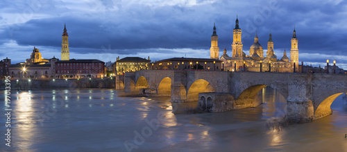 Zaragoza - The panorama with the bridge Puente de Piedra and Basilica del Pilar at dusk.